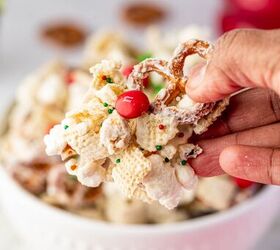 christmas crunch recipe easy holiday snack mix, A hand showing the Christmas Crunch snack mix with popcorn pretzels and red and green M Ms coated in white chocolate perfect holiday treat