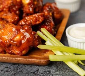 mango habanero wings air fryer mango habanero wing recipe, Close up image of Mango Habanero Wings on a wooden tray with celery and ranch