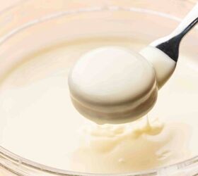 easy no bake white chocolate covered oreos 5 ingredient christmas tre, Dipping an Oreo into melted white chocolate using a fork and coating both sides evenly