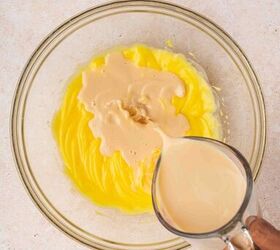 rumchata pudding shots recipe easy and festive with 5 ingredients, Slowly pouring RumChata liqueur into the pudding mixture while mixing on low speed creating a creamy blend with a cinnamon vanilla aroma