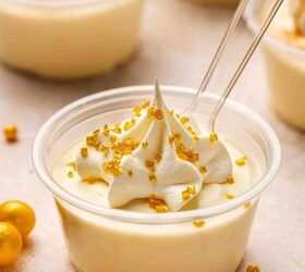 rumchata pudding shots recipe easy and festive with 5 ingredients, Close up of creamy RumChata pudding topped with whipped cream and golden sugar sprinkles being scooped with a small spoon for a rich velvety bite