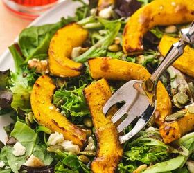 easy roasted pumpkin salad with feta balsamic vinaigrette, A fork lifting a bite of roasted pumpkin salad with greens feta and pumpkin seeds