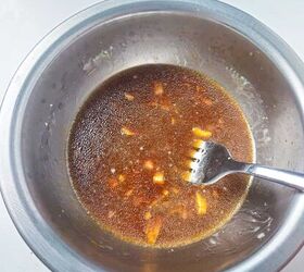 easy and delicious chicken and shrimp stir fry recipe, Seasoning sauce mixture with minced garlic and soy sauce in a metal mixing bowl