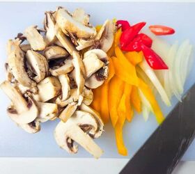 easy and delicious chicken and shrimp stir fry recipe, Fresh sliced mushrooms bell peppers chili peppers and onions on a cutting board with a knife