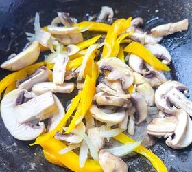 easy and delicious chicken and shrimp stir fry recipe, Mushrooms onions and bell pepper strips cooking together in a wok