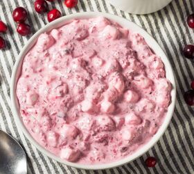 cranberry salad recipe simple cranberrry side dish, Overhead image of Cranberry Fluff in a white bowl with cranberries scattered around it