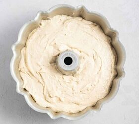 best eggnog pound cake rum eggnog glaze, A bundt pan filled with creamy light colored cake batter sits on a light textured surface ready to be baked