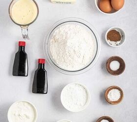 best eggnog pound cake rum eggnog glaze, A flat lay of baking ingredients including flour sugar eggs butter sticks vanilla extract sour cream baking soda salt baking powder eggnog and a small bowl of spices arranged on a light gray surface