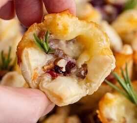 cranberry brie bites, Hand Picking Up Cranberry Brie Bite Garnished with Fresh Rosemary