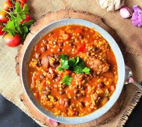 spicy tofu sausage bean soup with rice, A bowl of adzuki bean stew with tomotoes garlic and purple cauliflower in the background