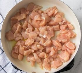 easy chicken broccoli rice casserole family favorite, Diced chicken breast pieces cooking in a skillet with olive oil for chicken broccoli rice casserole