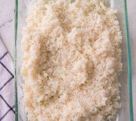 easy chicken broccoli rice casserole family favorite, Fluffy cooked white rice spread in a glass casserole dish as the base layer of chicken broccoli rice bake