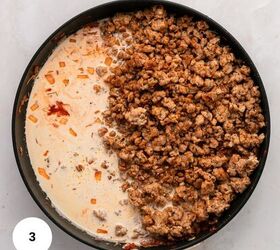 creamy italian sausage pasta with spinach, A skillet on a white surface contains cooked ground meat and onions on one side and a creamy reddish sauce for Italian Sausage Pasta on the other starting to mix together A white circle with the number 3 appears in the bottom left corner