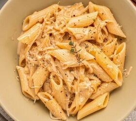 creamy italian sausage pasta with spinach, A beige bowl filled with creamy French Onion Pasta topped with shredded Gruy re cheese black pepper and a sprig of thyme A fork a gray napkin and fresh garlic are nearby