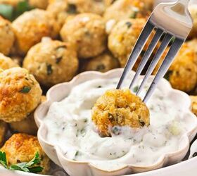 easy greek chicken and feta baked meatballs recipe gluten free, Chicken and feta meatball being dipped into creamy tzatziki sauce
