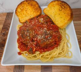 spaghetti and meatballs, Crispy garlic bread slices with spaghetti and meatball marinara on white plate