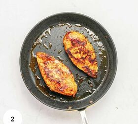 mediterranean chicken couscous bowl, A nonstick frying pan with two cooked browned chicken breasts on a white surface perfect for a Mediterranean inspired meal A small circle with the number 2 is in the lower left corner