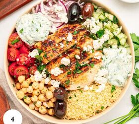 mediterranean chicken couscous bowl, A Mediterranean Chicken Couscous Bowl filled with grilled chicken couscous cherry tomatoes chickpeas cucumber Kalamata olives feta tzatziki sauce and fresh parsley each arranged in sections A number 4 is in the corner