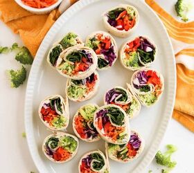 rainbow veggie pinwheels recipe easy and colorful, Veggie pinwheel wraps filled with broccoli carrots cabbage and spinach on a white serving platter