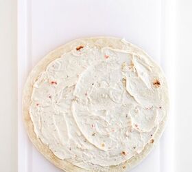 rainbow veggie pinwheels recipe easy and colorful, Flour tortilla evenly coated with creamy vegetable filling on a white cutting board