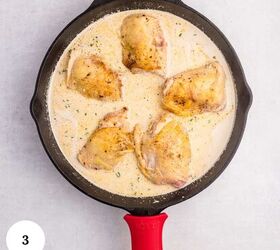 creamy chicken orzo bake one pan dinner, A cast iron skillet with five browned chicken thighs simmers in a creamy sauce reminiscent of a comforting chicken orzo bake The skillet featuring a red handle rests on a light colored surface viewed from above