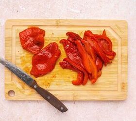 easy roasted red bell pepper and chickpea salad recipe, Slicing roasted red bell peppers into strips for chickpea salad
