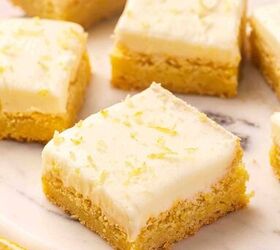 easy soft lemon sugar cookie bars best dessert for spring, Several lemon sugar cookie bars arranged diagonally on a marble slab with frosting and lemon zest garnish
