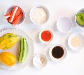 quick and easy spicy crab salad in just 15 minutes, Spicy crab salad ingredients including imitation crab mango cucumber avocado mayonnaise soy sauce sriracha and seasonings on a white surface