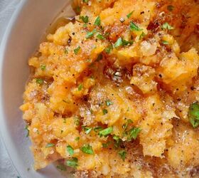 garlic brown butter mashed carrots and rutabaga, A bowl of mashed carrots and rutabaga topped with garlic brown butter and chopped parsley showing a rustic slightly chunky texture