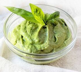 black garlic vegan pesto, A small glass bowl of creamy chili avocado pesto with a basil leave on the top