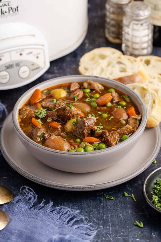 lamb stew crock pot, Crock Pot Lamb Stew in a bowl with a slow cooker and bread in the background