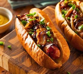 air fryer bacon wrapped hot dogs crispy bacon hot dog recipe, two air fryer bacon wrapped hot dogs on a wooden cutting board