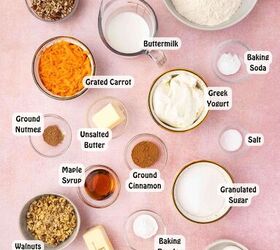 easy carrot cake muffins with cheesecake filling no frosting needed, All ingredients for carrot cake muffins with cream cheese filling and walnut streusel on a countertop including flour sugar butter eggs grated carrots cream cheese maple syrup pecans walnuts and spices