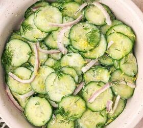 the best mexican fruit salad with tajin seasoning, Close up overhead shot of creamy cucumber dill salad showing texture of cucumbers red onions and dressing
