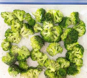 air fryer broccoli, Broccoli florets coated with seasoning inside a large clear resealable plastic bag viewed from above on a white background