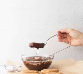 cashew butter reese s eggs gluten free and dairy free recipe, cashew butter reese egg being raised out of the dipped chocolate and letting the extra chocolate run off