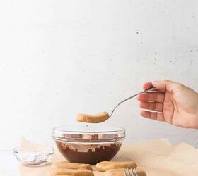 cashew butter reese s eggs gluten free and dairy free recipe, showing hand holding the cashew butter egg on a fork above the melted chocolate to dip