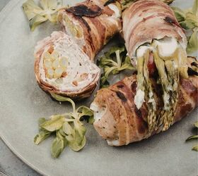 asparagus stuffed chicken thigh recipe keto stuffed chicken, Close up image of asparagus stuffed chicken thighs wrapped in bacon with one cut in half on a plate