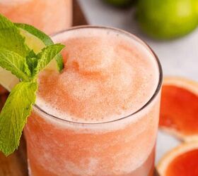 non alcoholic frozen paloma, top down view of non alcoholic frozen paloma served in a glass and garnished with a lime round and fresh mint with slices of grapefruit beside