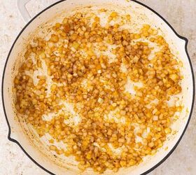 lemon chicken orzo pasta one pan, A white skillet with saut ed diced onions lightly browned and caramelized set on a light colored countertop