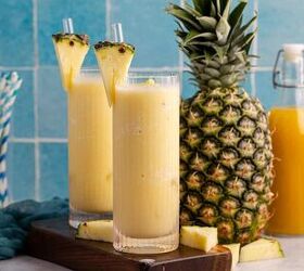 non alcoholic frozen pina colada, Two glasses of non alcoholic frozen Pina coladas with a pineapple in the back