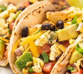 easy breakfast tacos with pico scrambled eggs, Close up of a breakfast taco topped with pico scrambled eggs avocado slices and cilantro