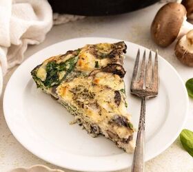 easy egg white frittata fluffy high protein, A slice of spinach and mushroom egg white frittata on a white plate with a fork next to fresh mushrooms greens and a dish of grated cheese The remaining frittata is visible in a skillet in the background