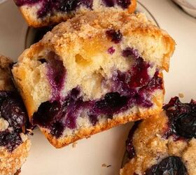 blueberry yogurt muffins with crumble topping, A close up of sliced blueberry yogurt muffins with a crumbly topping showing juicy blueberries baked inside the moist golden muffin The muffins are stacked on a beige plate