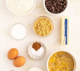 chocolate chip banana bread ultra moist easy, Ingredients for baking are arranged on a white surface including flour chocolate chips brown sugar butter granulated sugar spices eggs vanilla extract yogurt and a bowl of mashed bananas