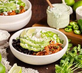 chicken tinga bowl perfect for weekly meal prep, Chicken Tinga bowl from above garnished with cilantro avocado and jalape os and a dressing in the background