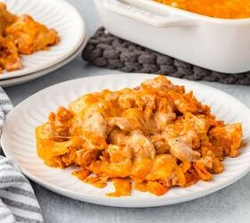 doritos casserole, A plate of cheesy nacho casserole sits on a white table The dish is topped with melted cheese and nacho chips A napkin forks and casserole dish are nearby creating a cozy dining setting