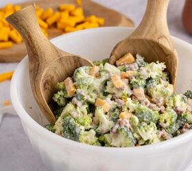 keto broccoli salad creamy crunchy and low carb, Keto broccoli salad in a bowl with serving spoons on a counter with cheese in the background