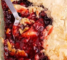 3 ingredient strawberry dump cake the easiest dessert you ll make, Strawberry Dump Cake in a baking dish with a serving spoon