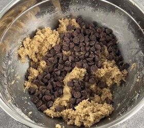 easy no bake cookie dough bark edible safe to eat, A metal mixing bowl containing cookie dough and a generous amount of chocolate chips on top set on a gray countertop